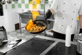 Modern kitchen. Cooks prepare meals on the stove in the kitchen of the restaurant or hotel. The fire in the kitchen. Royalty Free Stock Photo