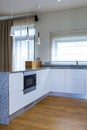 Modern kitchen design in light interior with wood accents.