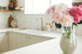 Modern kitchen design. Stylish brass faucet and white granite sink, kitchen cabinets with knobs and peonies bouquet in new Royalty Free Stock Photo