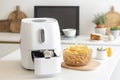 Modern kitchen with electric french fries machine - air fryer with french fries on table, closeup. Generative AI Royalty Free Stock Photo