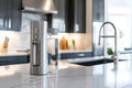 Elegant modern kitchen featuring a sleek water filter beside a glass filled with fresh water on a marble countertop Royalty Free Stock Photo