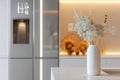 A modern kitchen features a digital fridge with a grocery list on the interface. A white vase holds delicate flowers on the Royalty Free Stock Photo