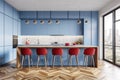 Modern kitchen interior with blue cabinets and red barstools, featuring herringbone wood floor patterns Royalty Free Stock Photo