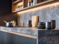 Modern kitchen interior featuring a sleek gray marble countertop with minimalist ceramic cups and soft under-cabinet lighting Royalty Free Stock Photo