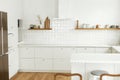 Modern kitchen interior. Stylish white kitchen cabinets with brass knobs, granite island, appliances and utensils on wooden Royalty Free Stock Photo