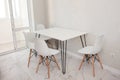 Modern kitchen interior with white dining table with four white chairs. Modern design, dining table and chairs in kitchen near Royalty Free Stock Photo