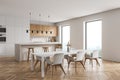 Modern kitchen interior with white walls  a wooden parquet floor and white countertops. A long table with chairs near it. 3d Royalty Free Stock Photo