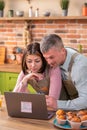 Modern kitchen island in the morning happy woman and her husband make a online shopping from the laptop they discussing Royalty Free Stock Photo