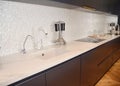 Modern kitchen metal faucet, cooker hood and ceramic kitchen sink. Ceramic kitchen sink with kitchen table.