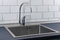 Modern kitchen metal faucet and stainless steel sink. Royalty Free Stock Photo
