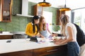 In modern kitchen, teen friends collaborating on creative project, sharing ideas enthusiastically Royalty Free Stock Photo