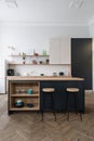 Modern kitchen with wooden cabinets and bar chairs near dining table Royalty Free Stock Photo