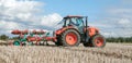 Modern Kubota tractor pulling a plough