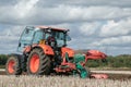 Modern Kubota tractor pulling a plough