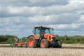 Modern Kubota tractor pulling a plough