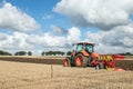 Modern Kubota tractor pulling a plough