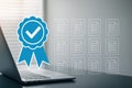 modern laptop with blue badge checkmark and transparent document icons symbolizing certification and management Royalty Free Stock Photo