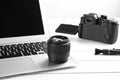 Modern laptop and camera lens on wooden table, closeup. Video production industry