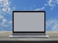 Modern laptop computer with blank screen on wooden table over blue sky with white clouds Royalty Free Stock Photo