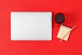 Modern laptop with cup of coffee and office tools on red background Royalty Free Stock Photo