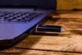 Modern laptop and flash memory card on a wooden desk Royalty Free Stock Photo
