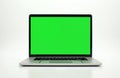Modern laptop open with bright green screen for editing. Silver portable computer sits on white surface, ready for graphic design Royalty Free Stock Photo