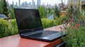 Modern laptop on a terrace, city view in background Royalty Free Stock Photo
