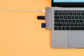 Modern laptop, USB Type-C adapter with a flash and charging on orange background Royalty Free Stock Photo