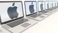 Modern laptops with Apple Inc. logo. Modern office building entrance. Computer technology conceptual editorial 3D