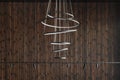 Modern led Pendant light lamp against wood wall, Elegant spiral ceiling Chandelier. Contemporary interior concept.