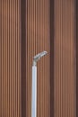 Modern LED solar power street light post against wooden trellis wall outside of vintage building Royalty Free Stock Photo