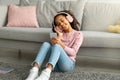 Modern leisure. Happy teen african american girl enjoying favorite songs, wearing wireless headphones Royalty Free Stock Photo