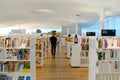 Modern library interior with book shelves and walking readers Royalty Free Stock Photo