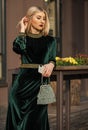 modern life. girl care gem stone handbag or purse. glam clutch accessory. elegant woman in green velour dress. glamour