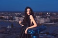 Modern life with princess in celebrity style. Luxury woman in evening dress with view on city. Girl with glamour makeup Royalty Free Stock Photo