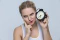 Modern Lifestyle Concepts. Young Stressfull Caucasian Female With Alarm Clock And Lifted Hand With Gesture Touching Face