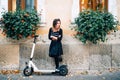 Lifestyle details, happy girl with flowers in urban city enjoying the electric scooter. Happiness and carefree concept Royalty Free Stock Photo