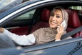 Cheerful muslim woman driving car, talking on smartphone Royalty Free Stock Photo