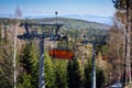 Modern lift to the mountains in the background of the spring forest