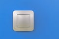 Modern light switch on blue wall representing energy saving Royalty Free Stock Photo