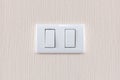 Modern light switch on a creamy wallpaper Royalty Free Stock Photo