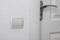 Modern light switch on white wall near door Royalty Free Stock Photo