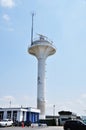 A modern lighthouse on the shore. View of the lighthouse against the blue sky on a summer day