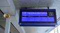 A modern live departure train board above a Warsaw platform.