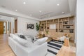 Modern living room features sleek dark hardwood flooring and wood paneled walls