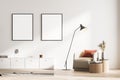 Modern living room interior with an armchair and commode, lamp. Two mock up framed posters on white wall. Reading and relax Royalty Free Stock Photo