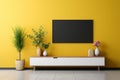 Modern living room with TV wall console, lamp, table, and flora on vibrant yellow wall