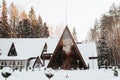 Modern loft architecture, country house in shape of triangle with frame windows in pine snowy forest on winter day, exterior