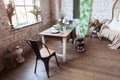 Modern loft living room with high ceiling, sofa, empty white brick wall, wood floor, design accessories, dining table Royalty Free Stock Photo