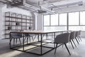 Modern loft meeting room interior with bookshelves, concrete flooring, furniture and panoramic window with city view and daylight Royalty Free Stock Photo